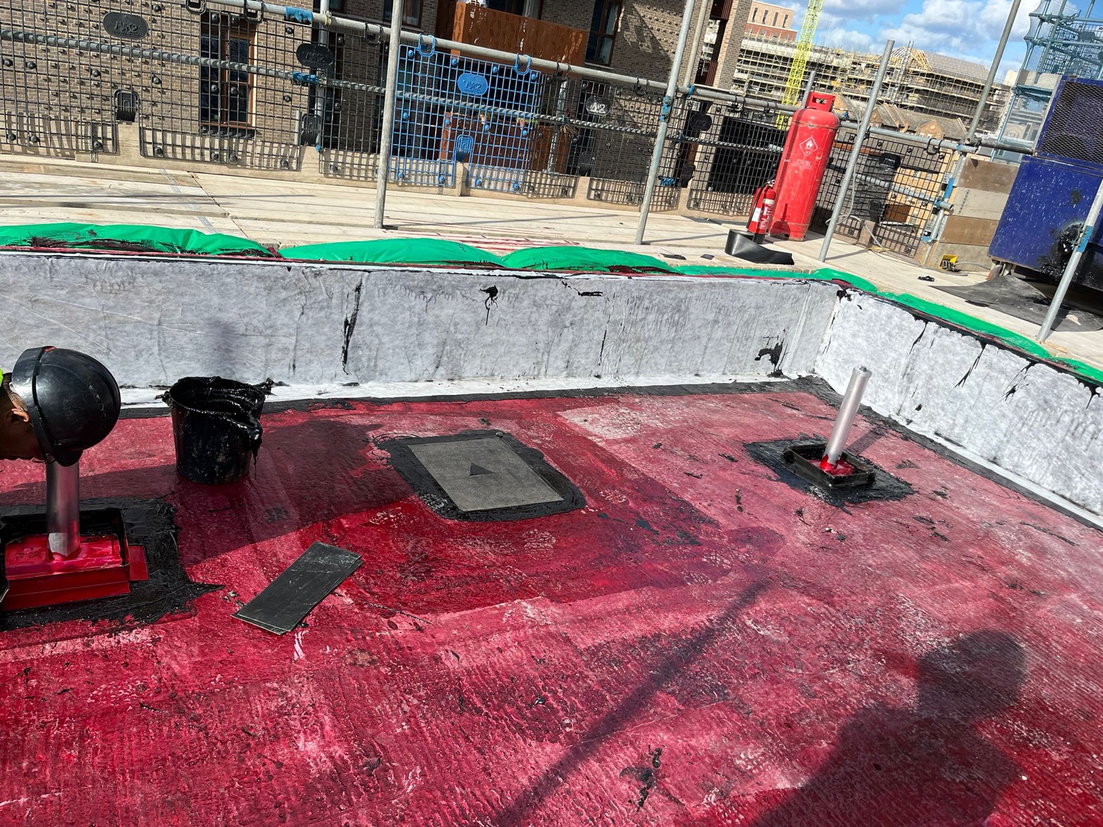 Reinforced waterproofing detail around flat roof upstands.