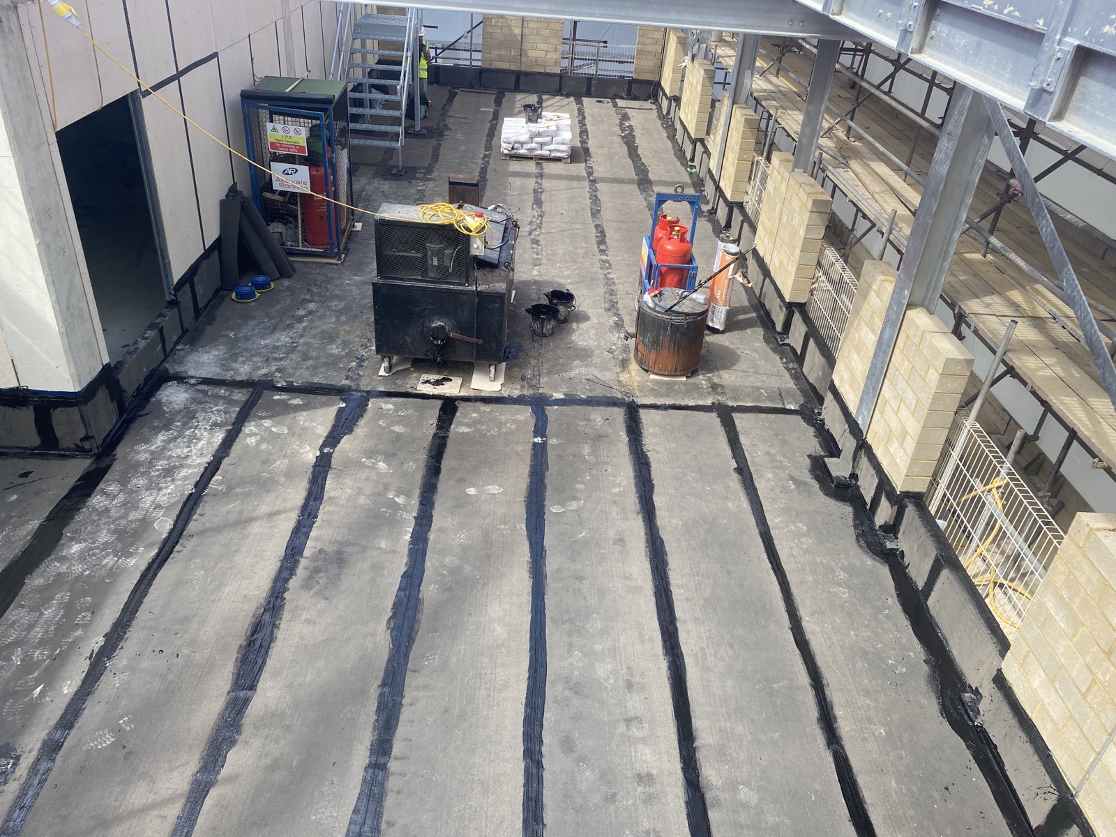 Hot melt waterproofing work around outlets and roof penetrations.